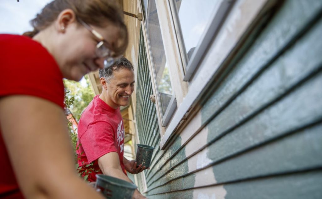 two people painting a house