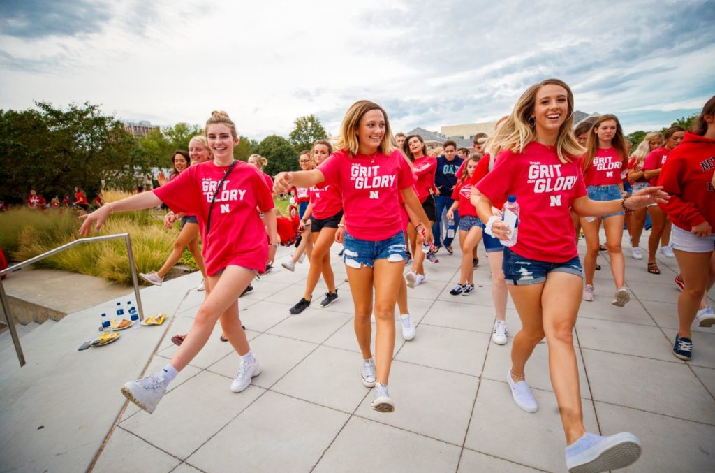 students dancing down a sidewalk
